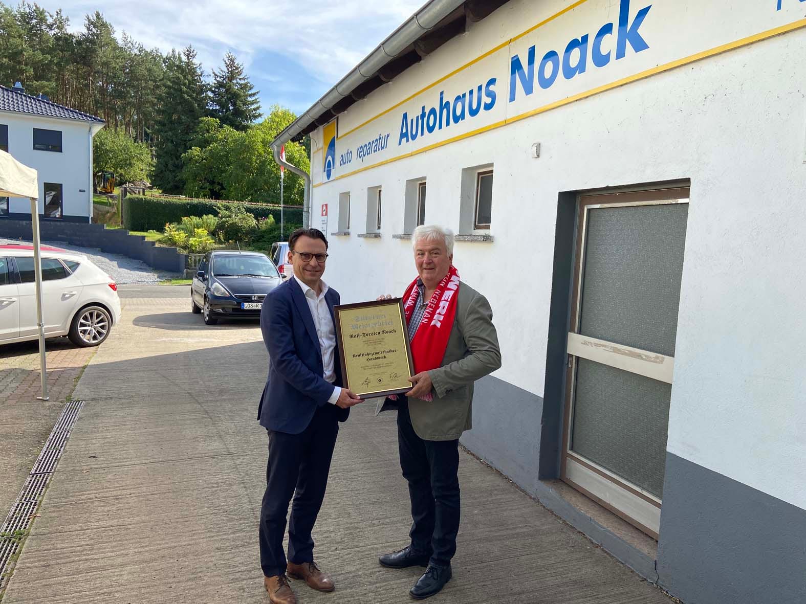 Übergabe des Silbernen Meisterbriefs durch die Handwerkskammer vor dem Betriebsgebäude der Autohaus Noack GmbH