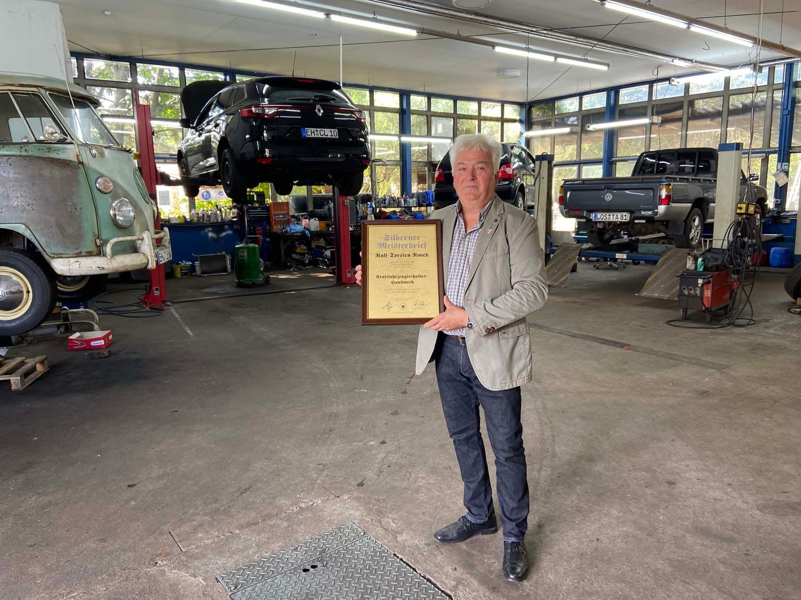 Kfz-Meister Ralf-Torsten Noack mit dem Silbernen Meisterbrief in der Werkstatt der Autohaus Noack GmbH